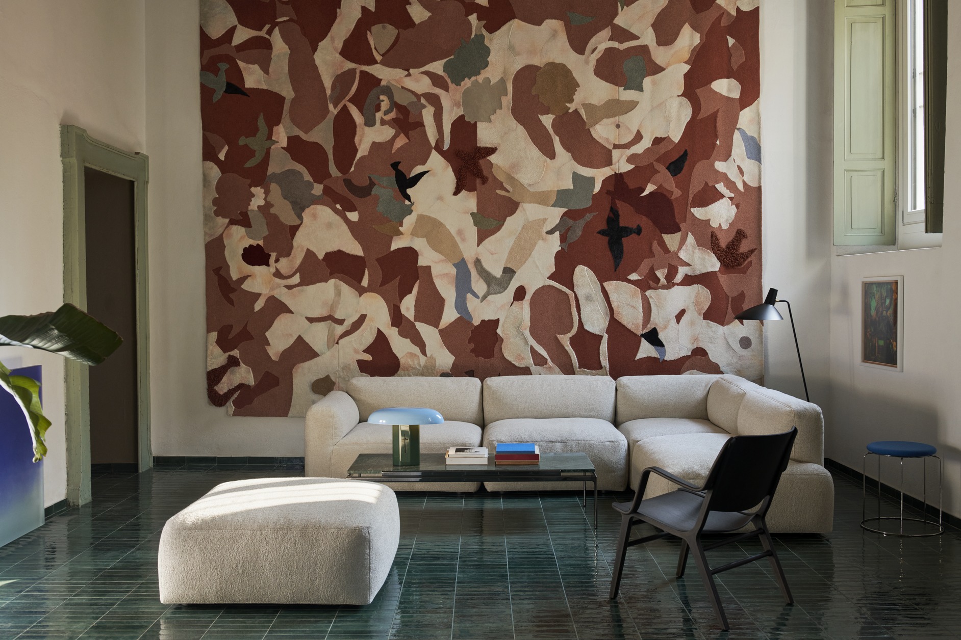 Wohnzimmer mit Sett Couchtisch von AndTradition, beigem Sofa, Teppich und grünen Fliesen.