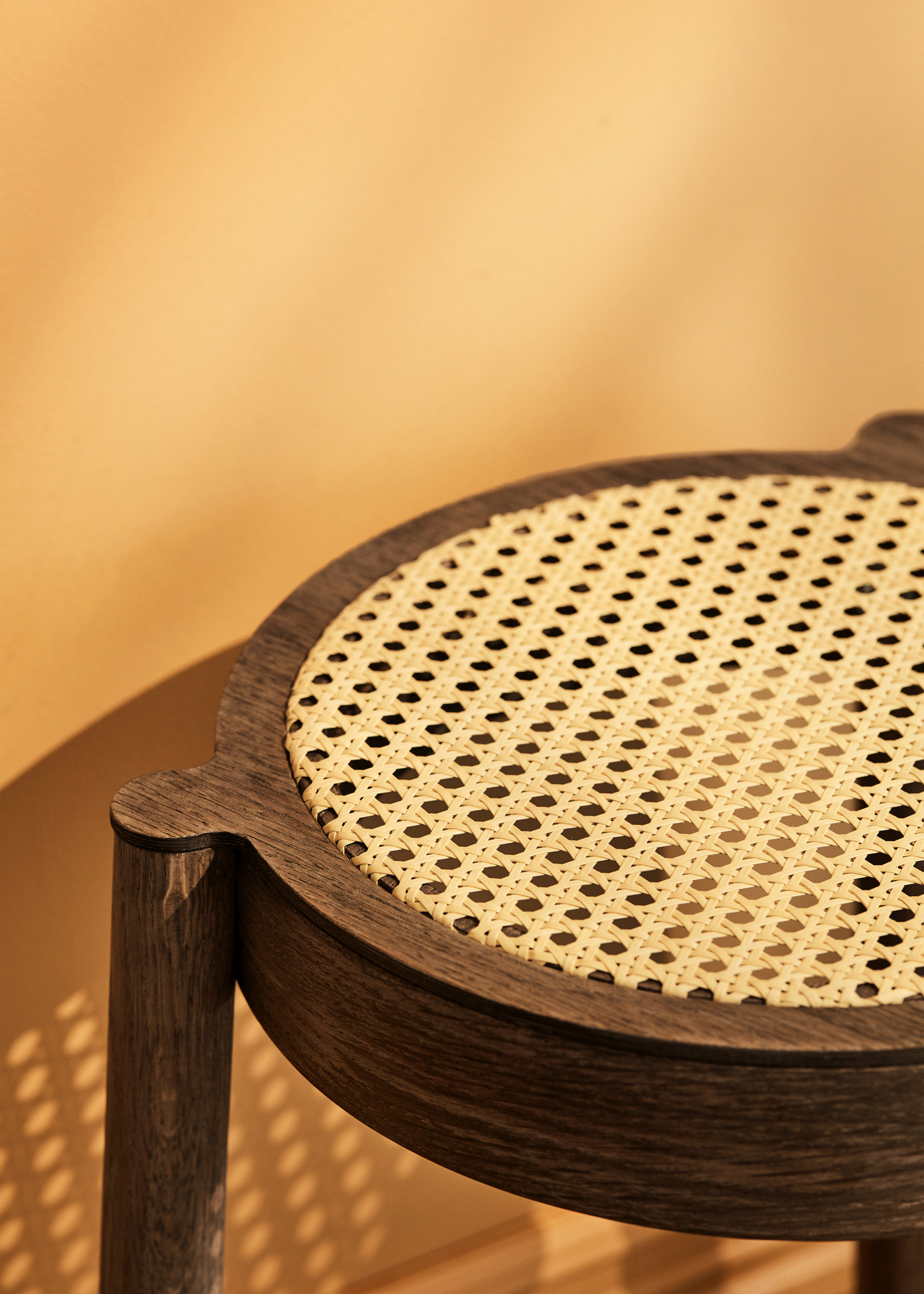 Detailansicht des Pal Hockers: Geräucherte Eiche mit hellem Netzgewebe von Northern. Stapelbarer Hocker.