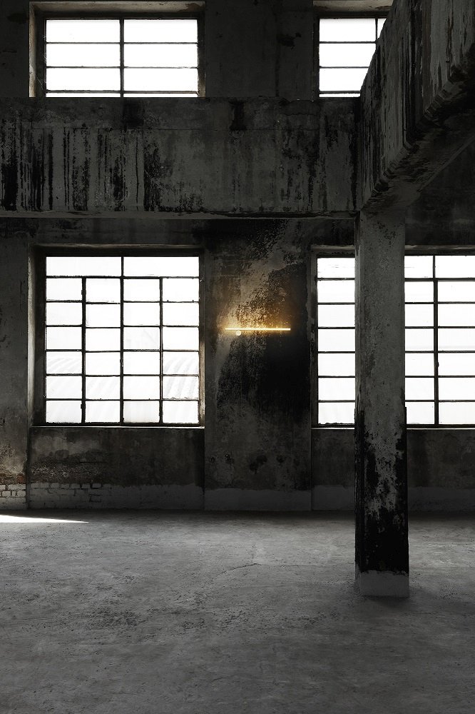 Flos Coordinates Wandleuchte in einem Raum mit großen Fenstern und Betonwänden. Moderne Wandlampe.