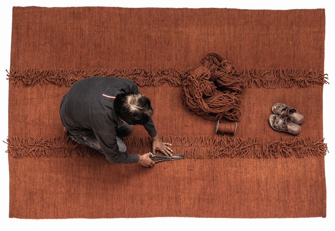Handgefertigter brauner Mía Teppich von Nanimarquina (200x300cm) in der Produktion, Detailaufnahme der Fransen und des Arbeitsprozesses.