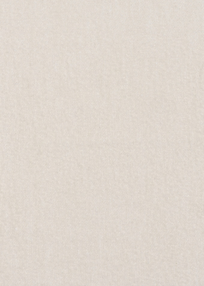 Detailaufnahme des elfenbeinfarbenen Stoffbezugs des Pacha Ottoman Harp von Gubi. Textur und Farbe des Hockers.