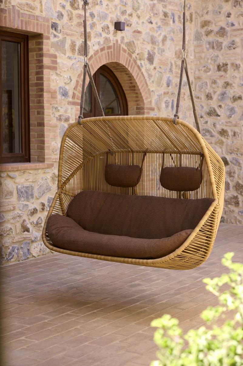 Hive Hängesofa von Cane-Line: Outdoor-Sofa aus Rattan mit braunen Kissen für zwei Personen.