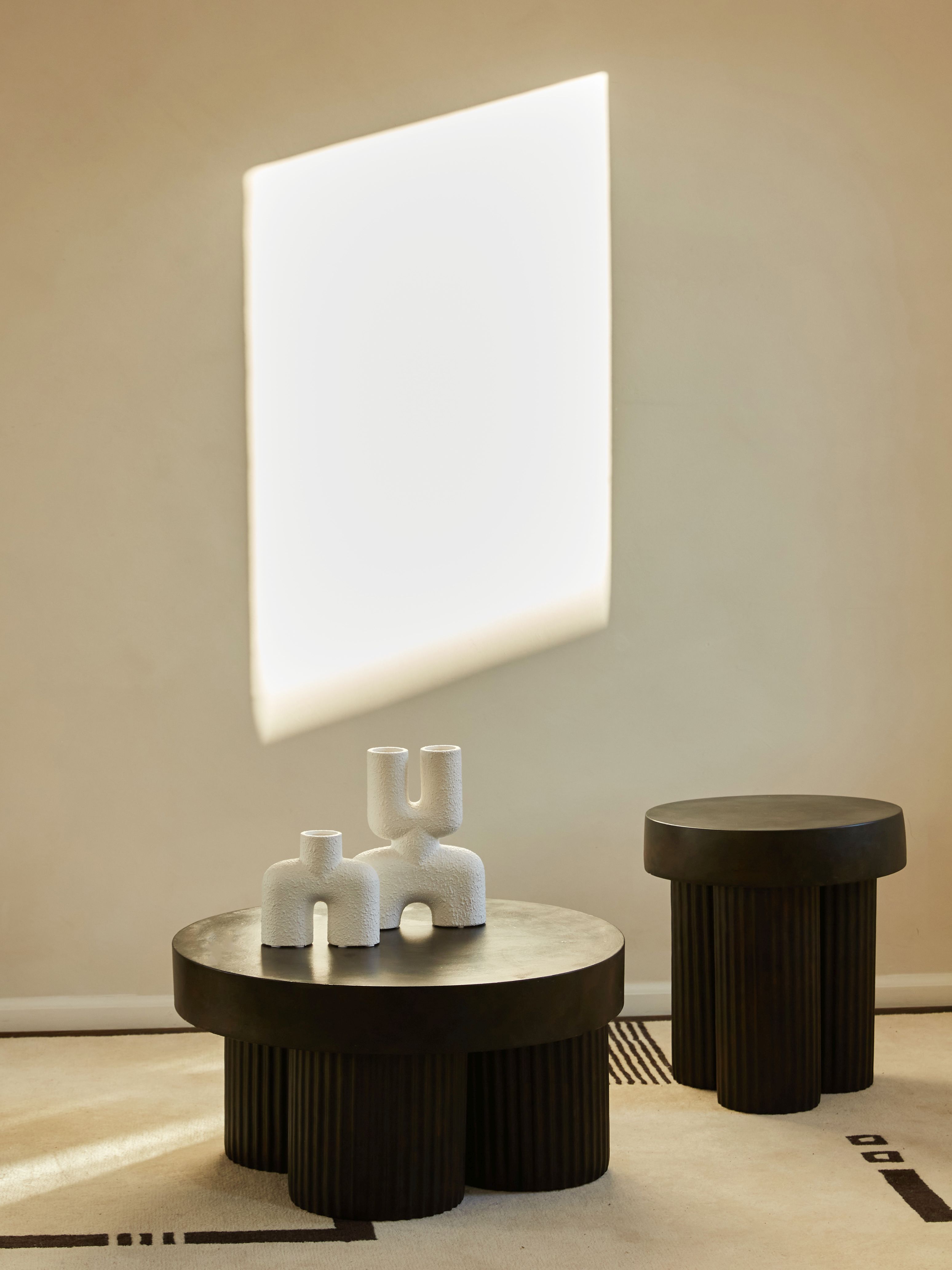 Gear Beistelltisch von Norr11 in dunklem Holz, mit dekorativen Vasen auf einem Teppich.