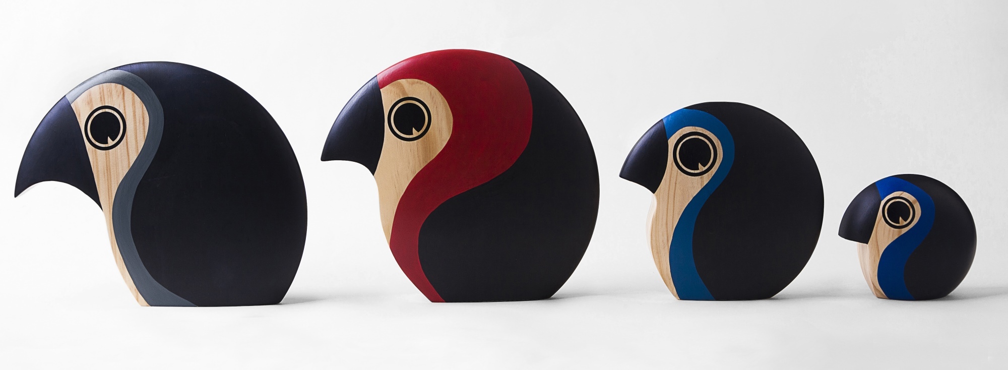 Vier Architectmade Discus Holzfiguren in verschiedenen Größen und Farben, modernes Design.