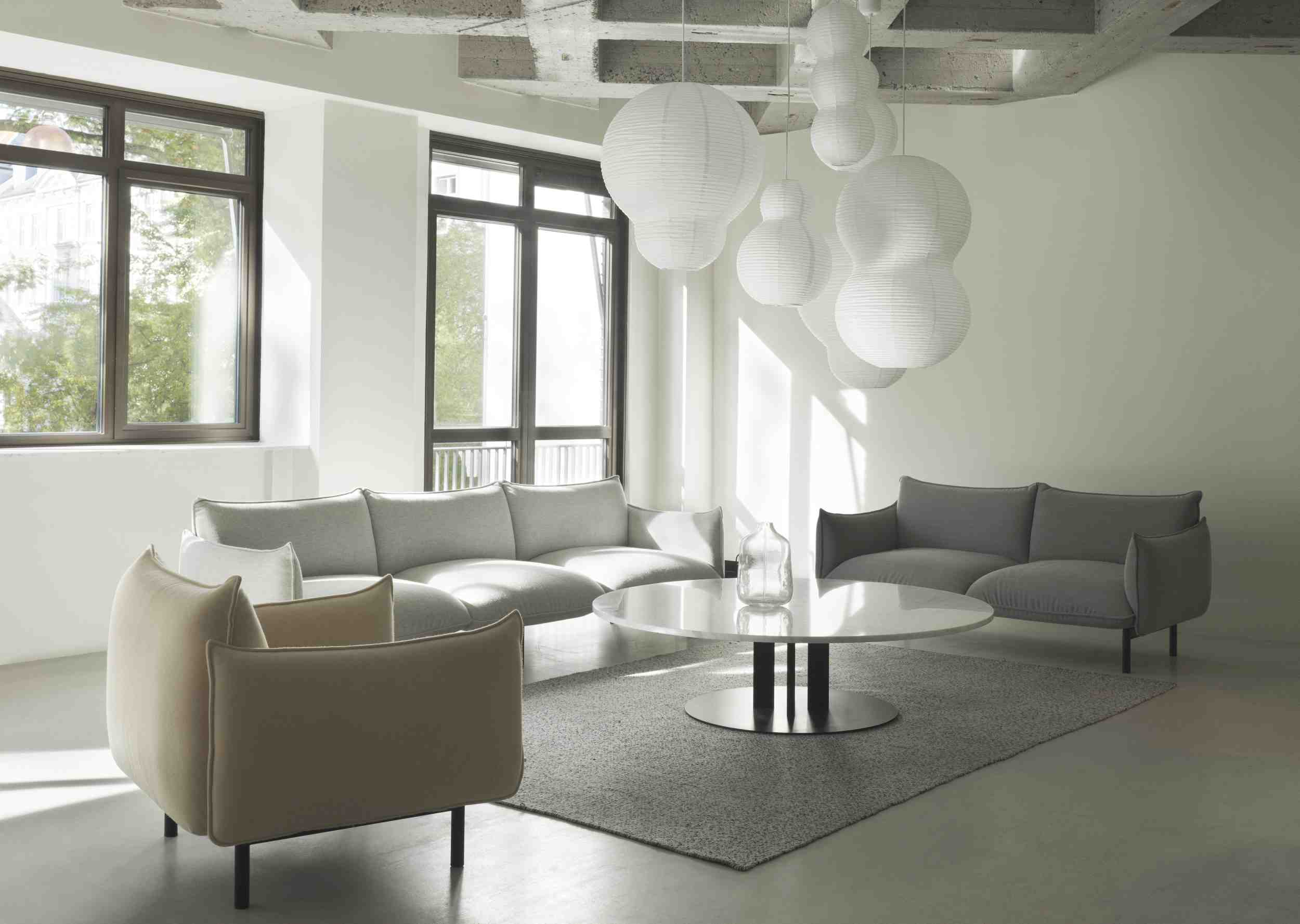 Wohnzimmer mit Ark Lounge Chair Sessel von Normann Copenhagen, Sofas und rundem Marmortisch.