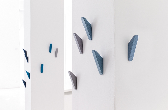 Cut Wandhaken von Schönbuch in Blau- und Grautönen an einer weißen Wand. Moderne Garderobenhaken.