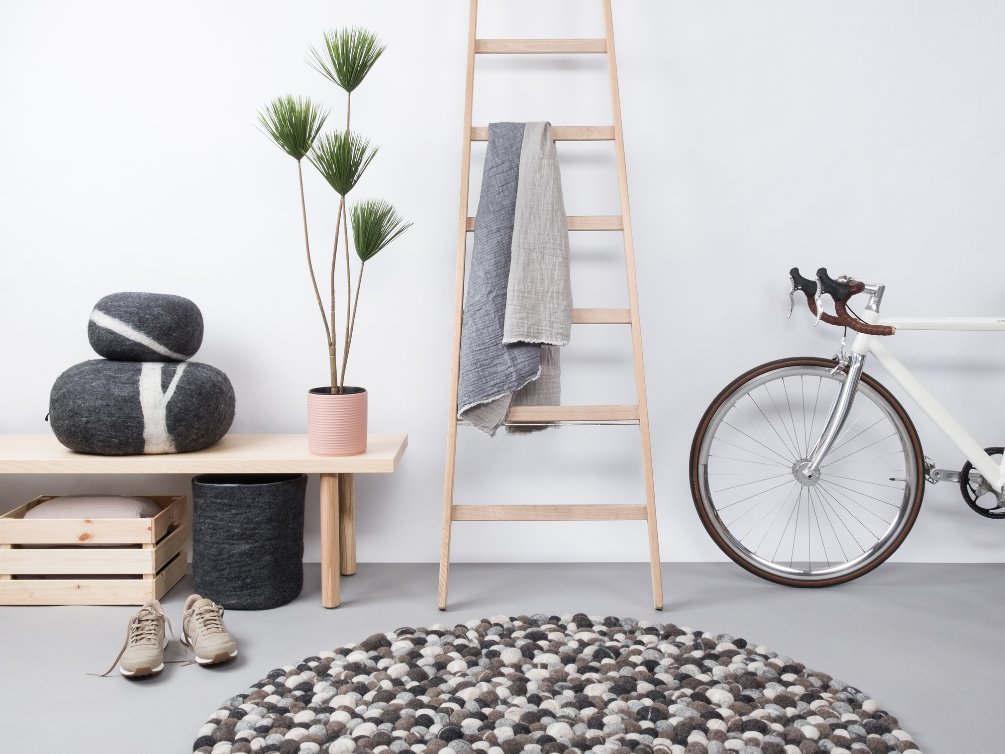 Runder Filzkugel Teppich 180 cm in Grau- und Weißtönen im modernen Raum.