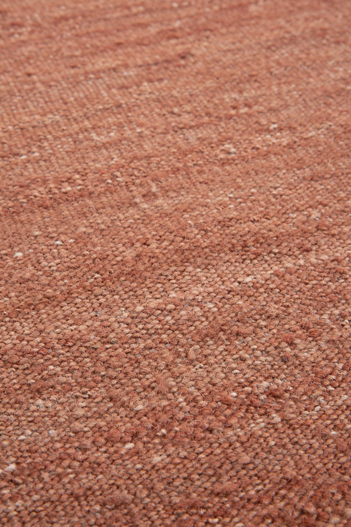 Detailaufnahme des Terracotta Nomad Kilim Teppichs von Ethnicraft, der eine warme, erdige Textur zeigt.