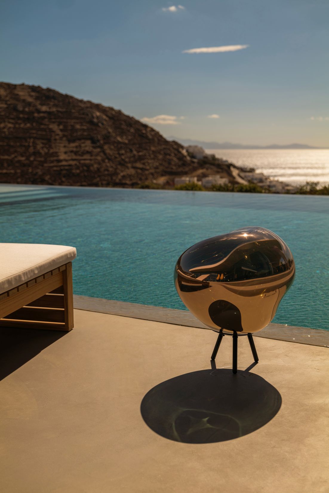 Goldene Melt LED Leuchte von Tom Dixon am Pool, moderne Bodenleuchte.