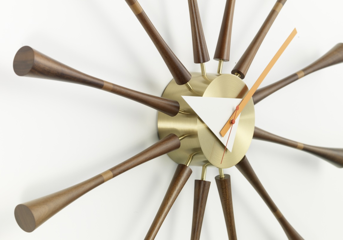 Nahaufnahme der Vitra Spindle Clock Wanduhr mit Holzspindeln und goldenem Zifferblatt. Designklassiker für Wohnzimmer.
