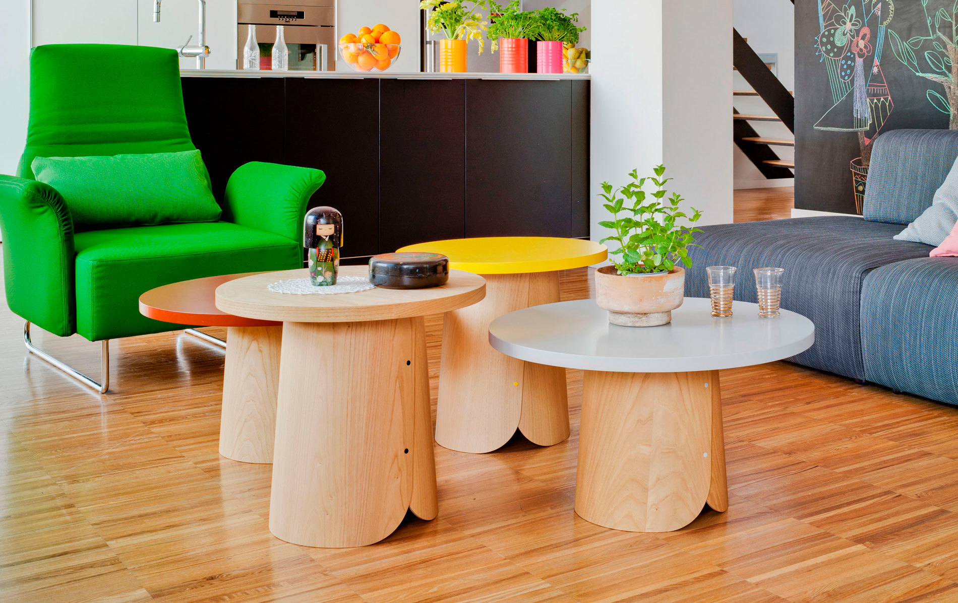 Mehrere Sancal Tab Beistelltische in Orange, Gelb und Weiß im modernen Wohnzimmer. Holztisch mit Pflanze.