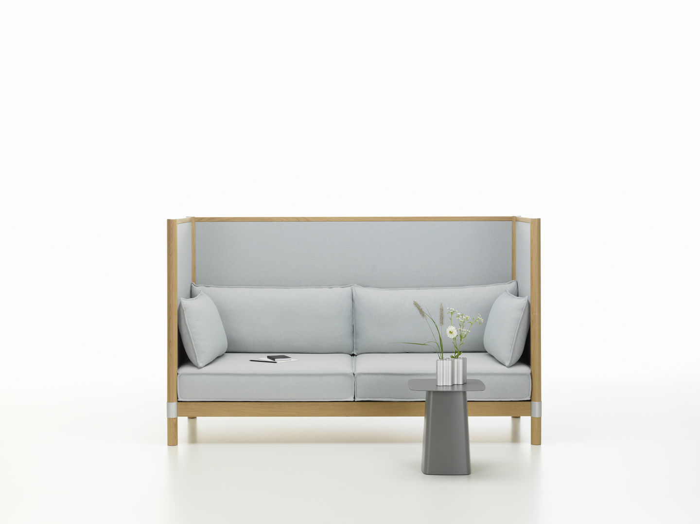 Grauer Metal Side Table Beistelltisch von Vitra neben einem hellblauen Sofa mit Holzelementen.