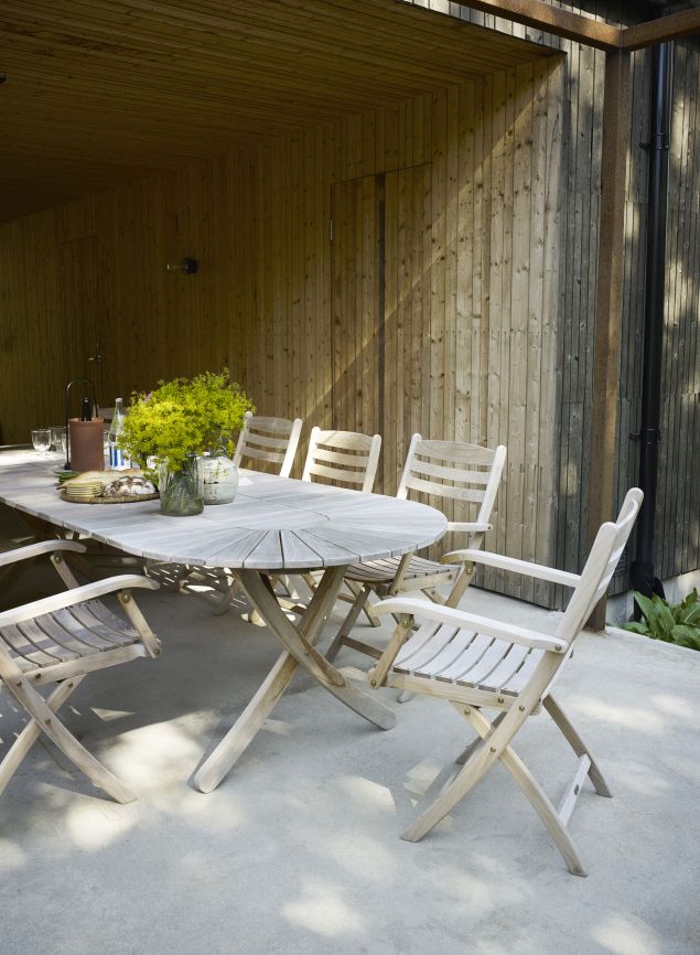 Selandia Esstisch Outdoor von Skagerak by Fritz Hansen mit Stühlen auf einer Terrasse.