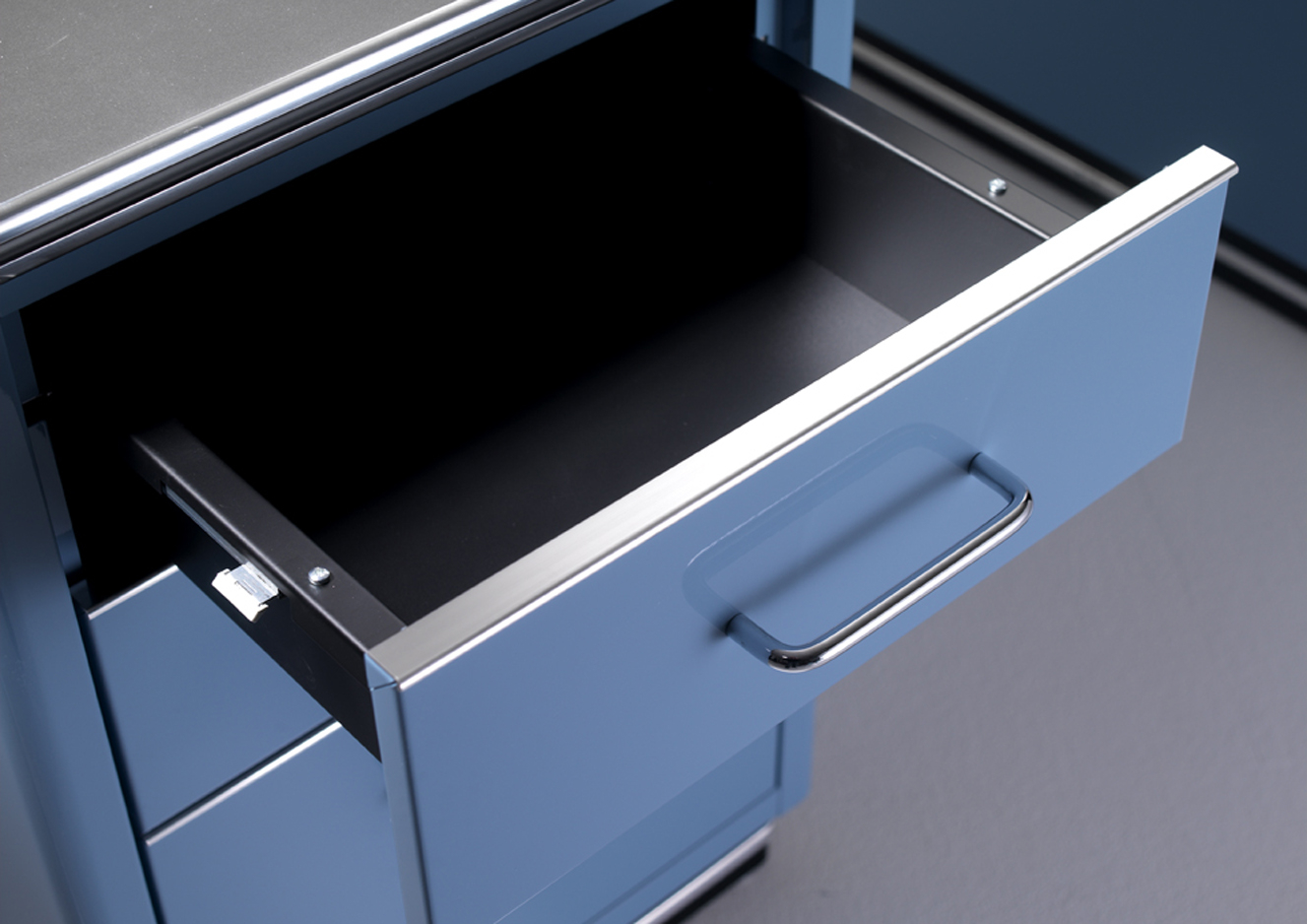 Detailaufnahme eines geöffneten Schubladenfachs vom TB 225 Classic Line Schreibtisch von Müller Möbelfabrikation in blau.