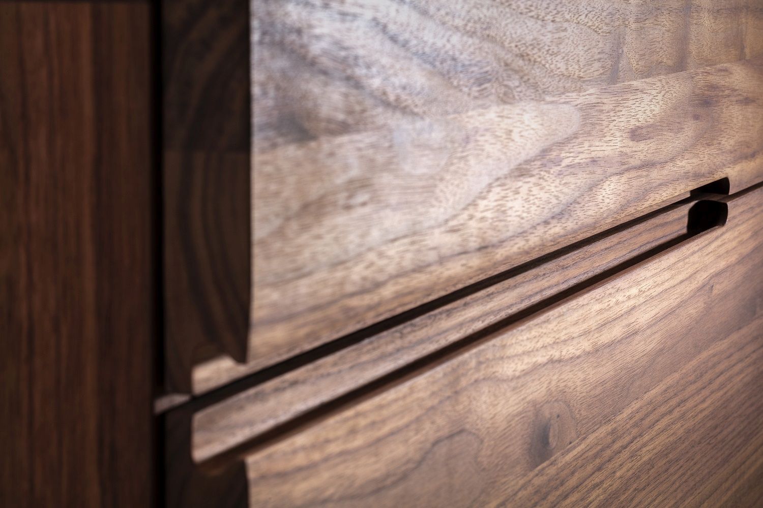 Detailaufnahme des Nightstand 64 Nachttischs aus dunklem Nussbaumholz mit Schublade und Griffmulde.