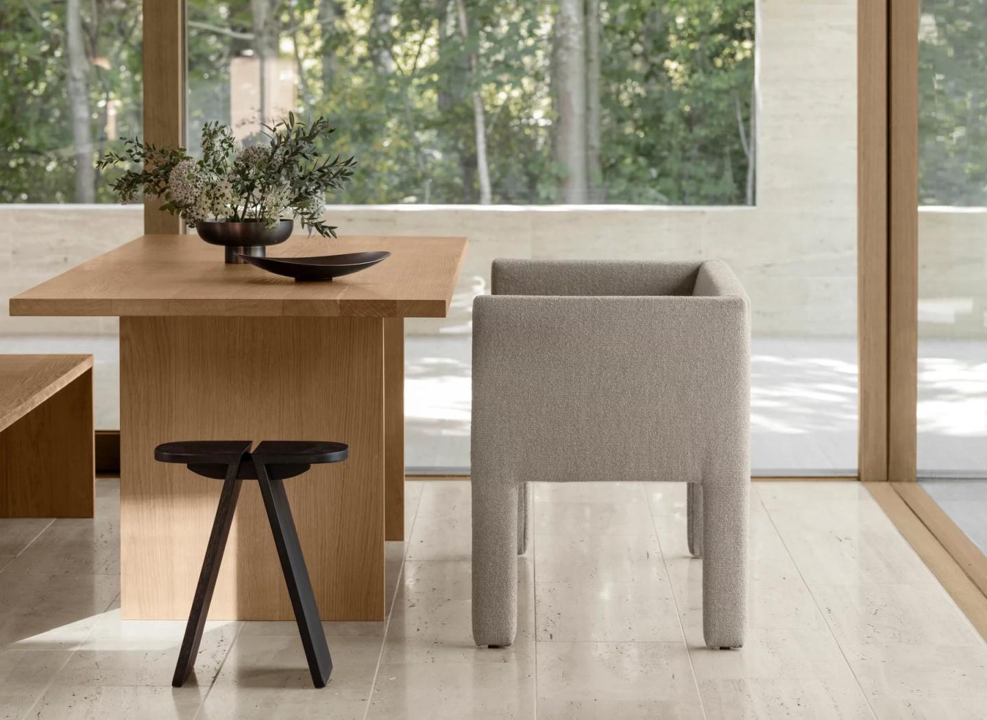 Beigefarbenes Sitta Sofa von Blomus neben Holztisch und Hocker in modernem Interieur.