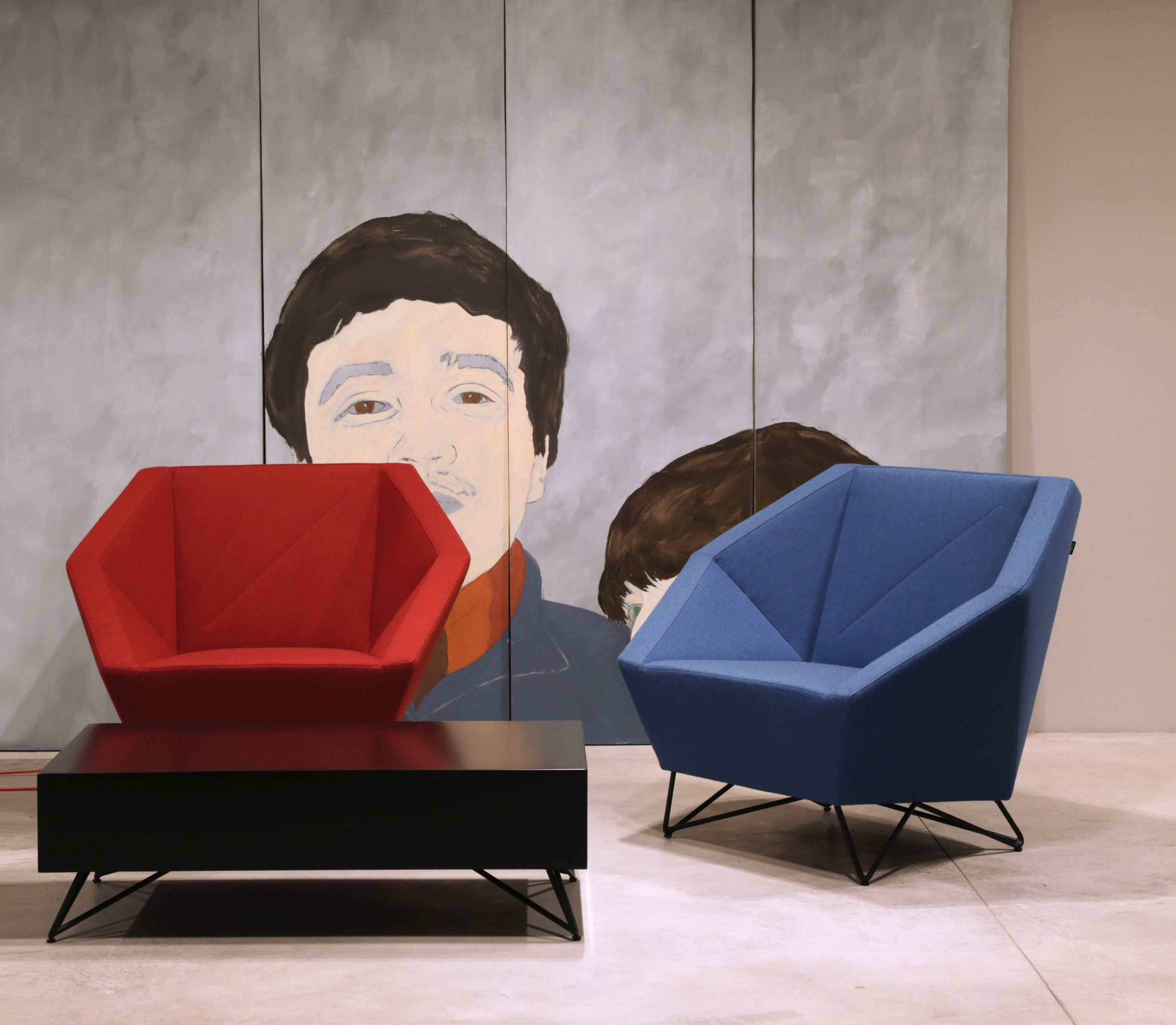 Roter und blauer 3angle Armsessel von Prostoria mit schwarzem Tisch vor Kunstwerk.