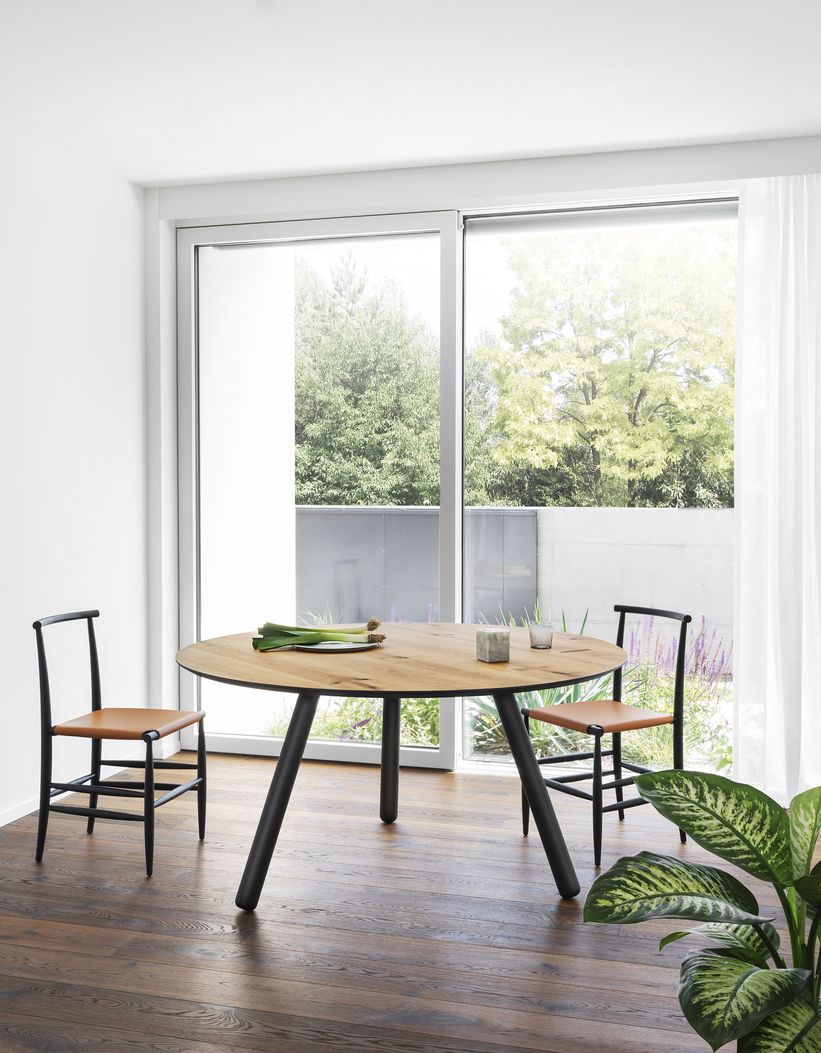 Runder Pixie Tisch von Miniforms mit schwarzem Gestell und zwei Stühlen im Esszimmer.