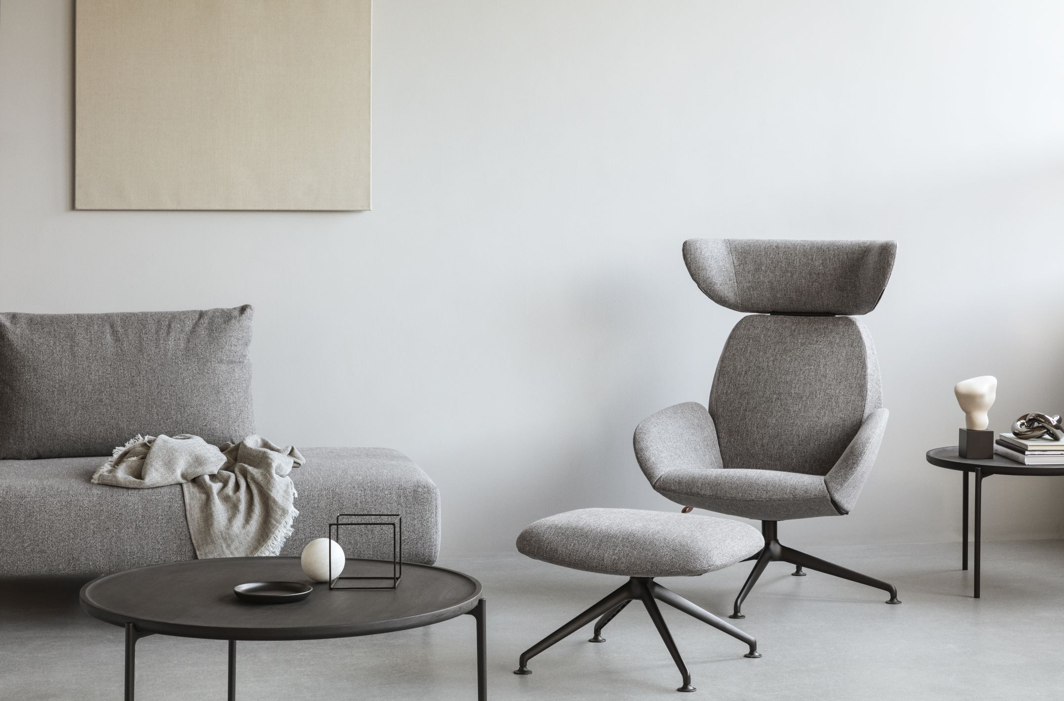 Grauer Laze Fußhocker von Eva Solo mit schwarzem Fußkreuz in modernem Wohnzimmer.