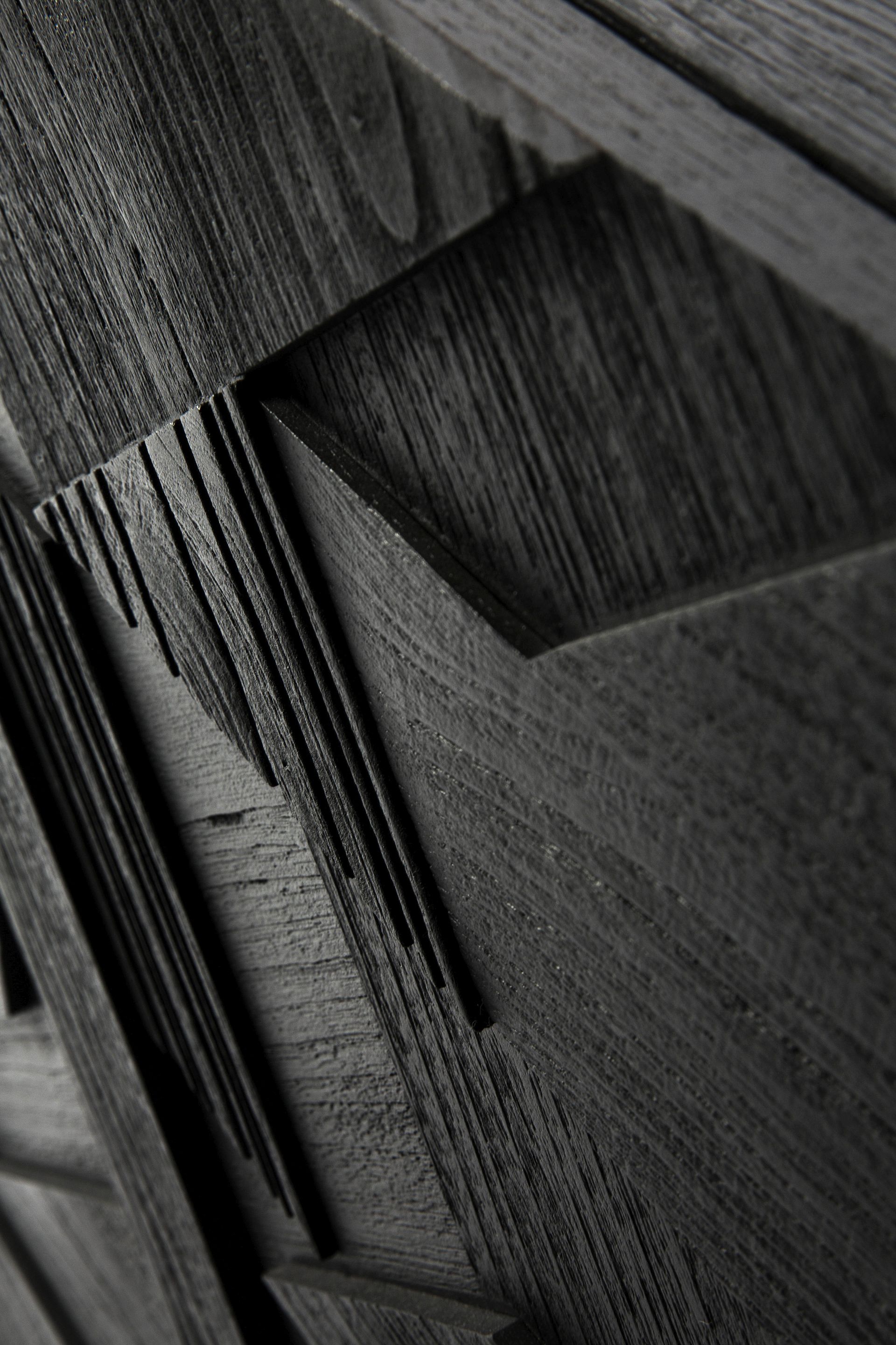 Detailaufnahme der schwarzen Graphic Teak Anrichte von Ethnicraft mit grafischem Muster und Holzstruktur.