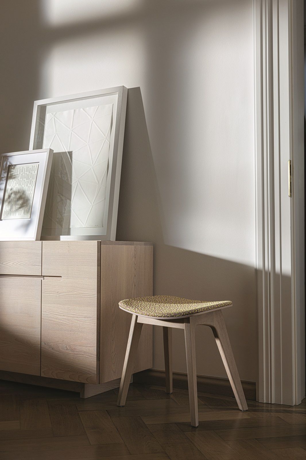 Sideboard aus Massivholz mit hellen Holzfronten und Hockern im modernen Wohnraum.