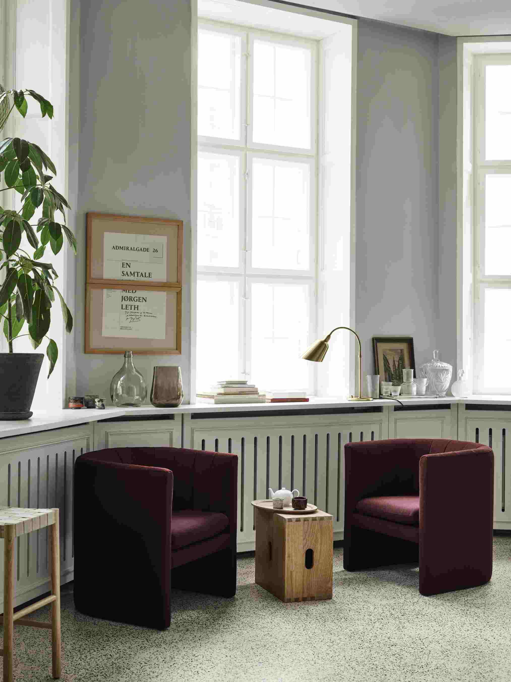 Zwei rote Sessel und ein Holzhocker im Raum, ähnlich dem Andtradition Betty TK8.