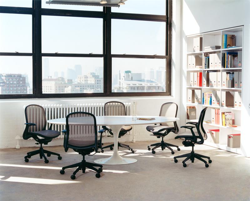 Ovaler Saarinen Esstisch von Knoll International mit Tulip Fuß und Bürostühlen in hellem Raum.