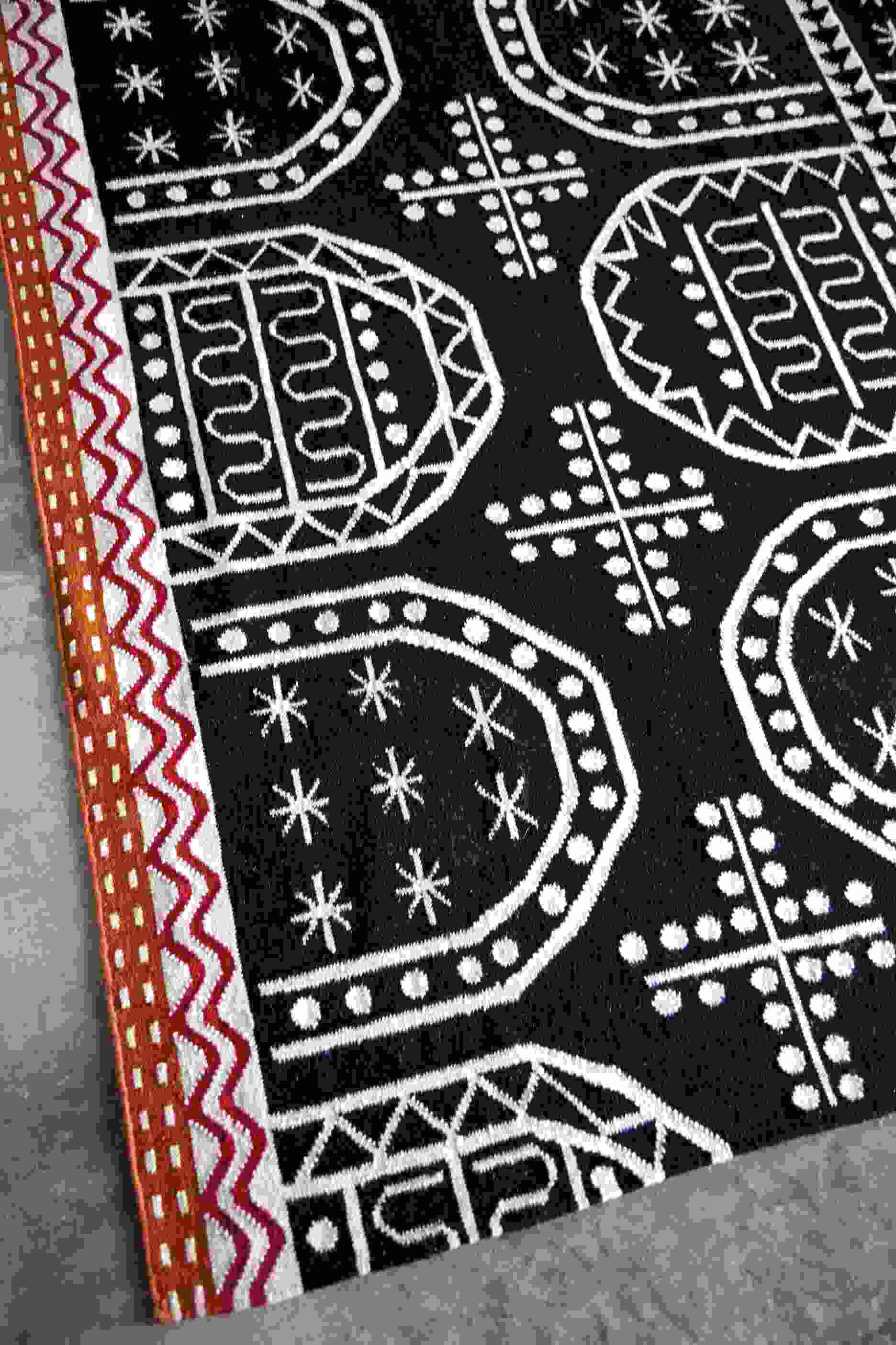 Detailaufnahme des Kilim Tasili Teppichs mit traditionellen, schwarzen und weißen Mustern.