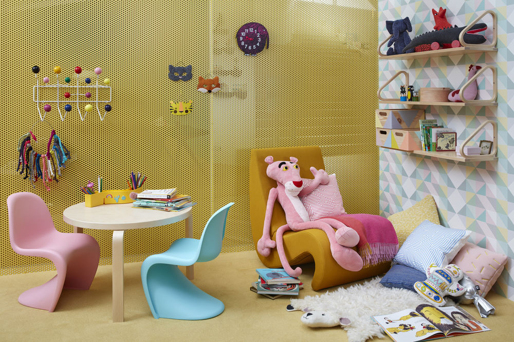 Kinderzimmer mit Möbeln: Tisch, Stühle, Regale, Deko-Elemente und Plüschtiere für eine gemütliche Atmosphäre.