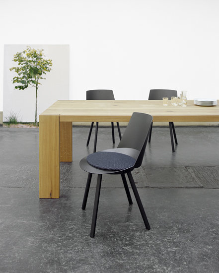 Heller TA17 London Esstisch von e15 mit Stühlen und Geschirr im minimalistischen Interieur.