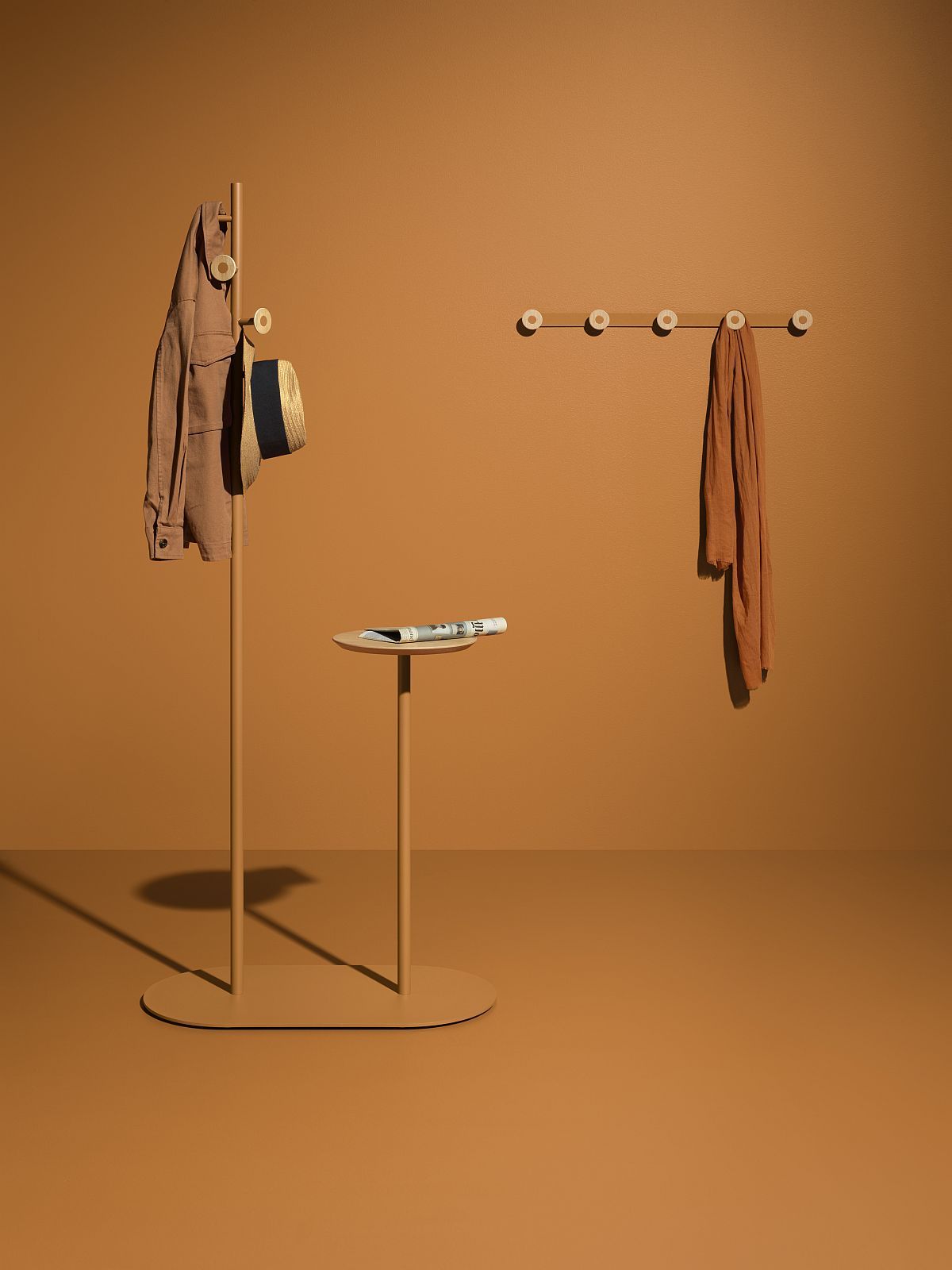 Moderner Garderobenständer mit Jacke und Hut, Wandgarderobe mit Schal, Beistelltisch mit Zeitung, brauner Hintergrund.