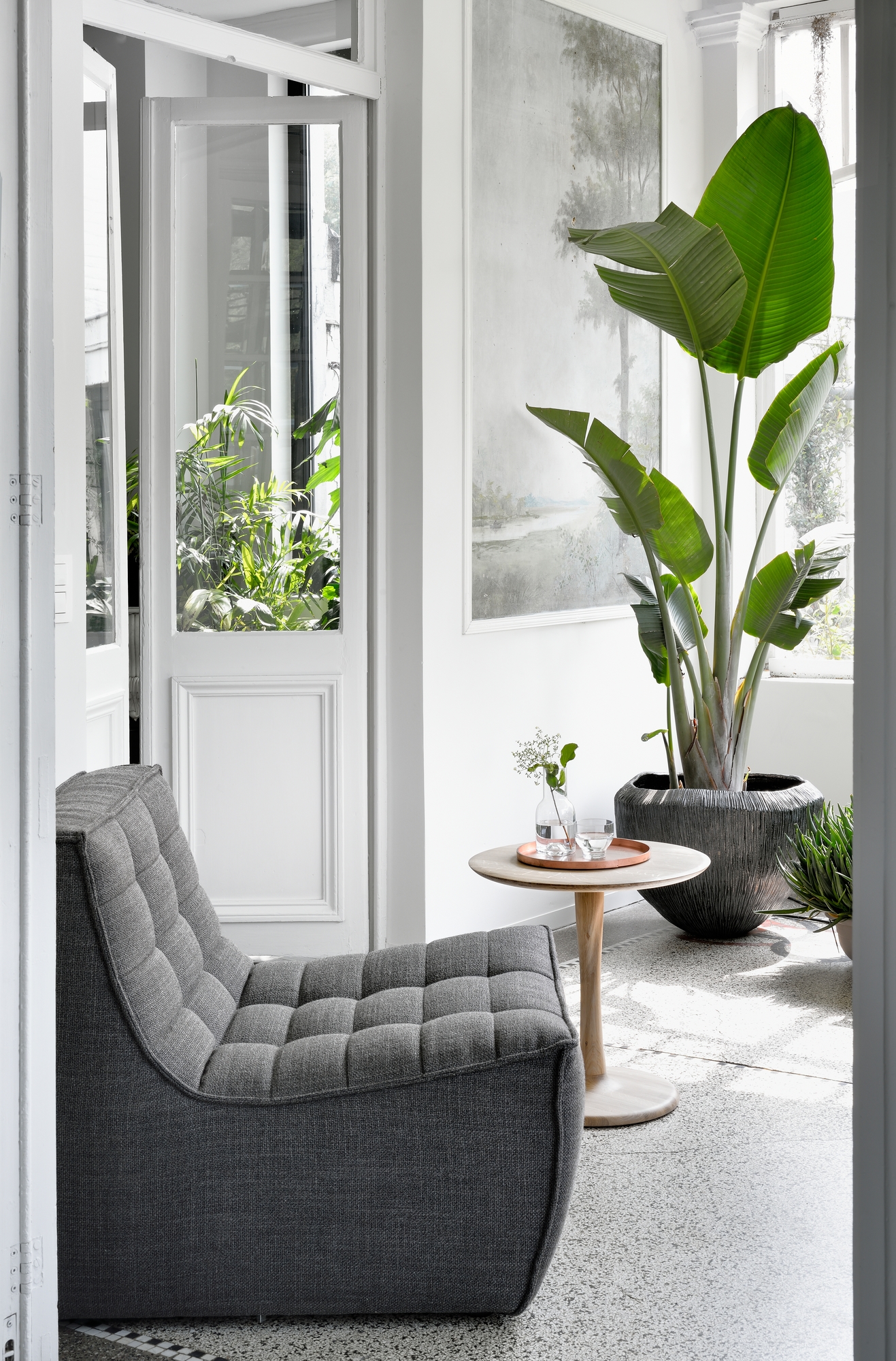 Grauer Sessel N701 von Ethnicraft mit gesteppter Oberfläche in einem hellen, modernen Wohnraum.