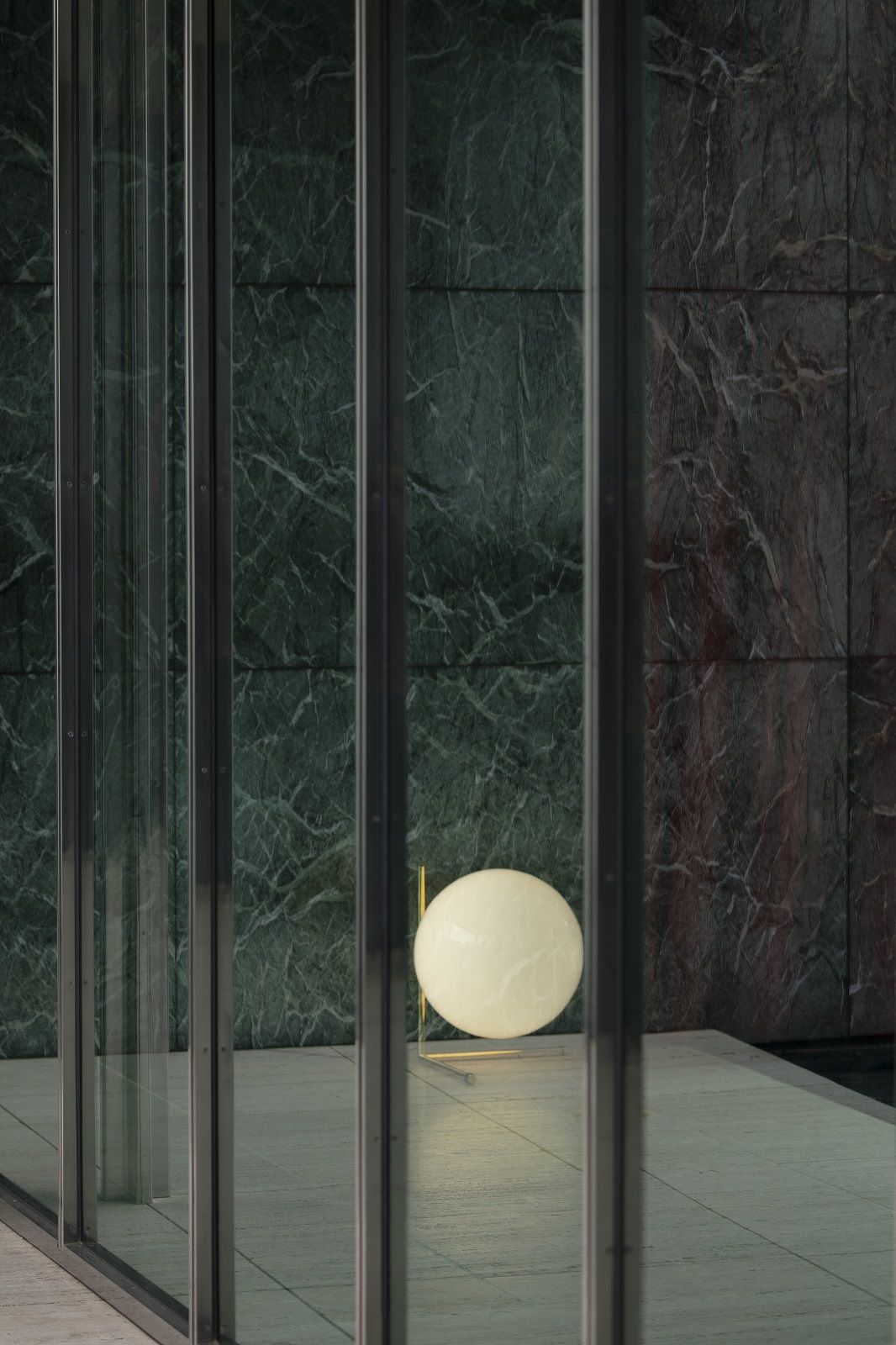 IC T3 Tischleuchte von Flos: Runde, leuchtende Kugel auf Messinggestell, moderne Tischlampe.