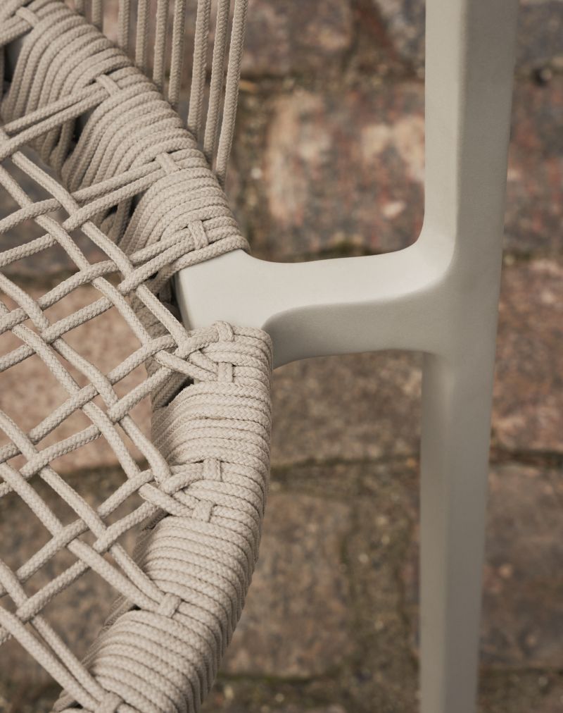 Detailaufnahme: Geflochtener Lagrasse Stuhl von Vipp, Outdoor-Möbel mit grauem Rahmen.