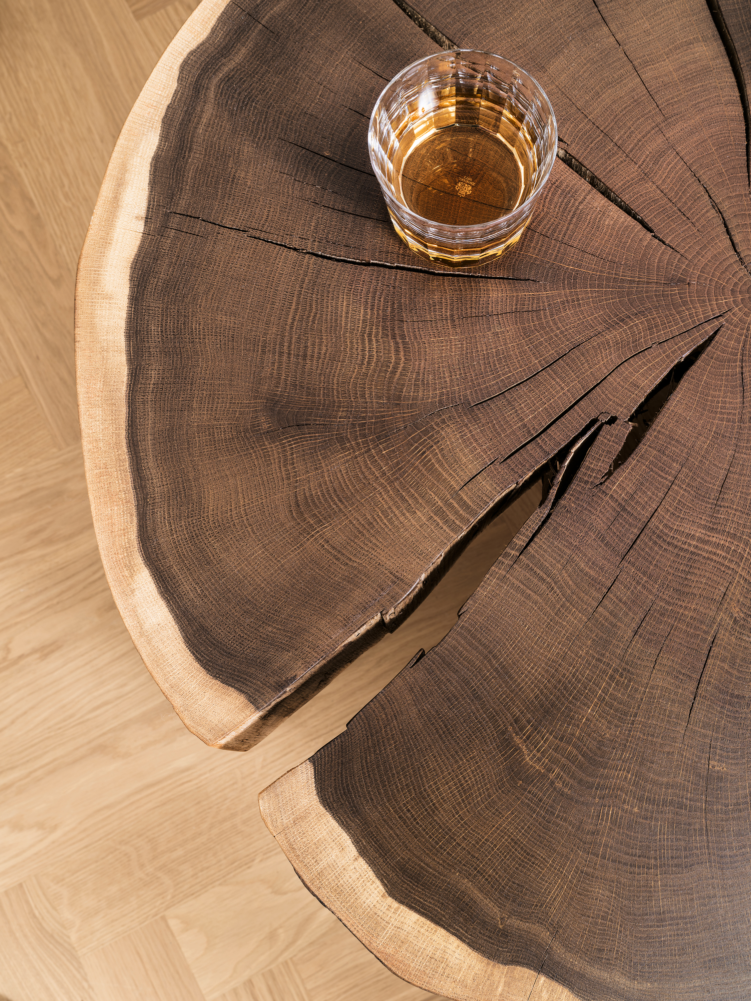 Nahaufnahme: Janua Stomp Beistelltisch H40 aus roher Eiche mit Getränk im Glas.