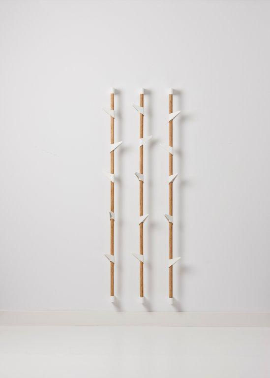 Cascando Bamboo Wandgarderobe mit drei Reihen aus Bambusstäben und weißen Haken.