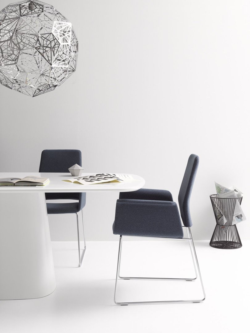 Conic Tisch mit Stühlen in modernem Büroambiente, minimalistisches Design mit weißem Tisch und blauen Stühlen.