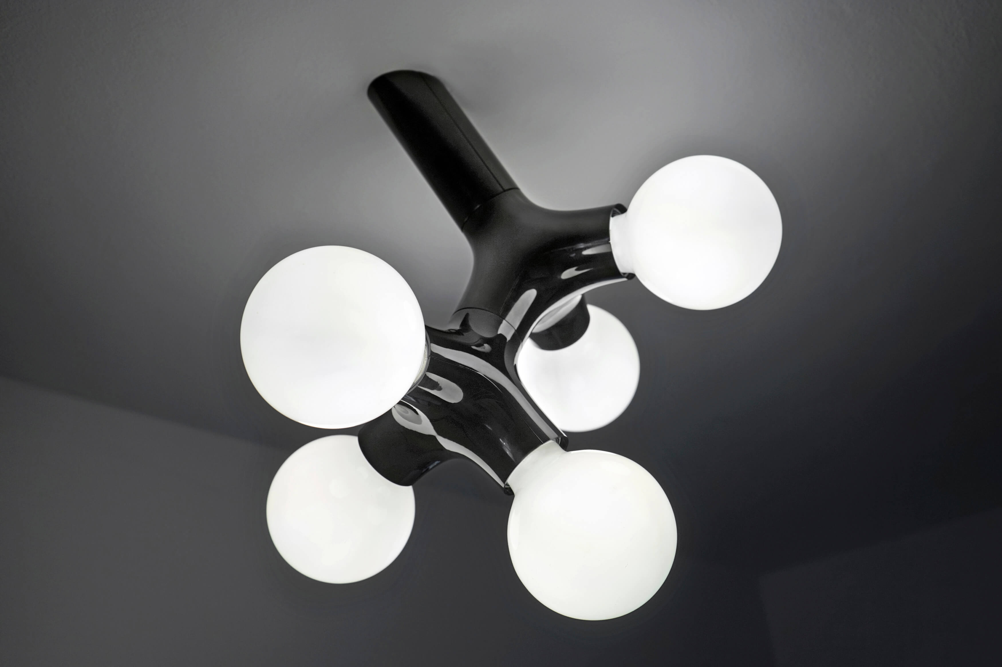 Schwarze DNA Wandleuchte mit fünf runden, weißen Leuchtkörpern. Moderne Deckenleuchte für Wohnzimmer und Schlafzimmer.