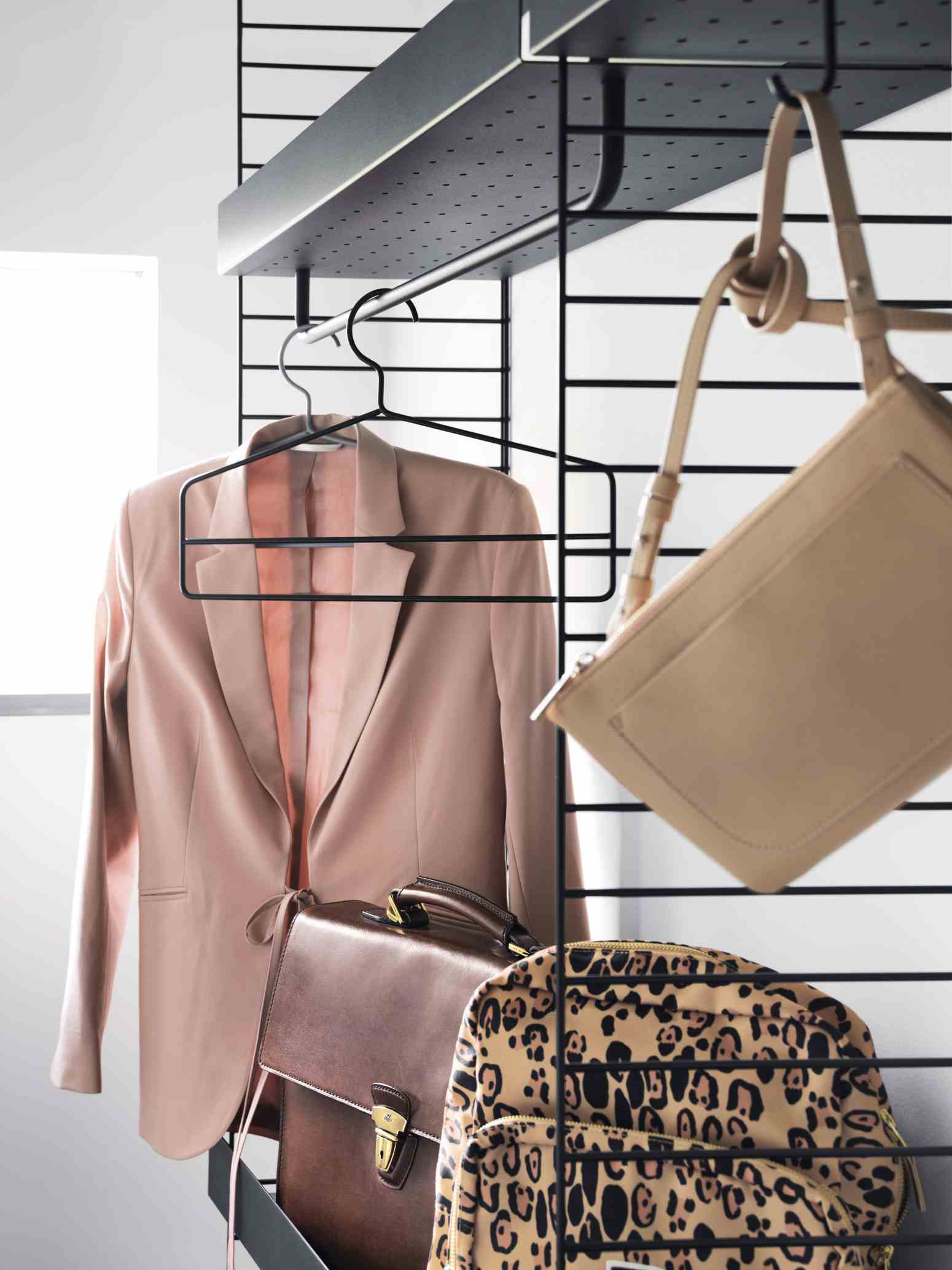 String Regalsystem mit Kleidung und Taschen. Bodenstehendes Regal von String Furniture.