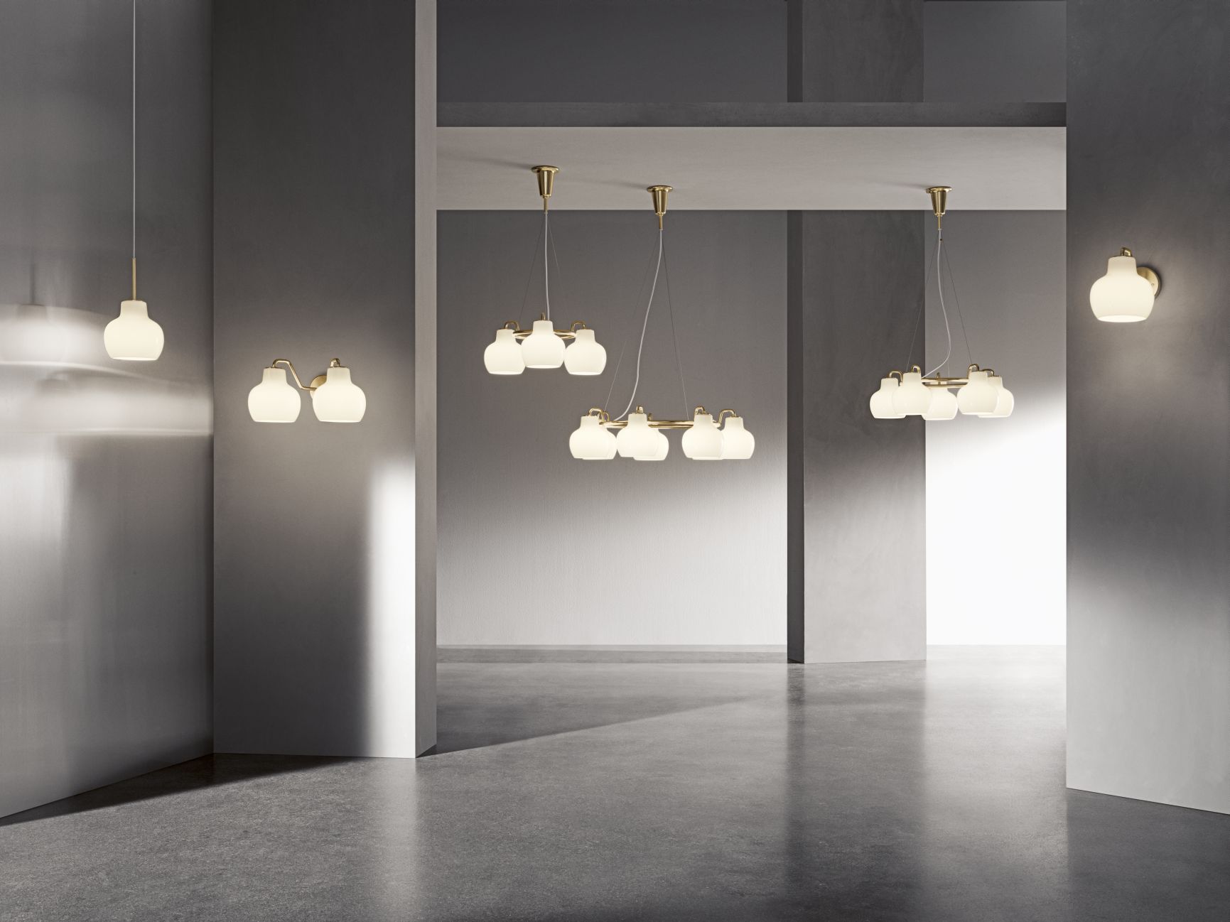 Innenaufnahme mit verschiedenen VL Ring Crown Lampen von Louis Poulsen: Wandleuchte, Pendelleuchte mit Messingdetails und Opalglas.