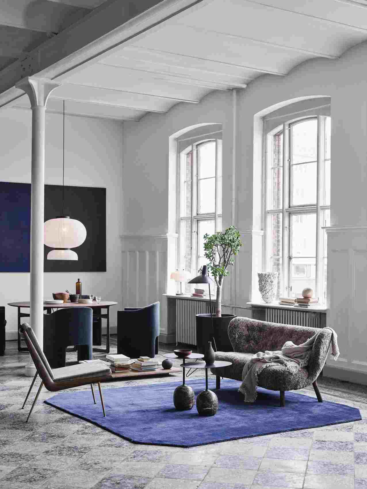 AndTradition Boomerang Lounge Chair HM1 Sessel in stilvollem Wohnzimmer mit Teppich und Designermöbeln.