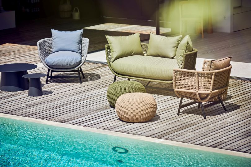 Suka Loungesofa von Jan Kurtz, hellgrau, mit Outdoor-Möbeln und Pool auf einer Holzterrasse.