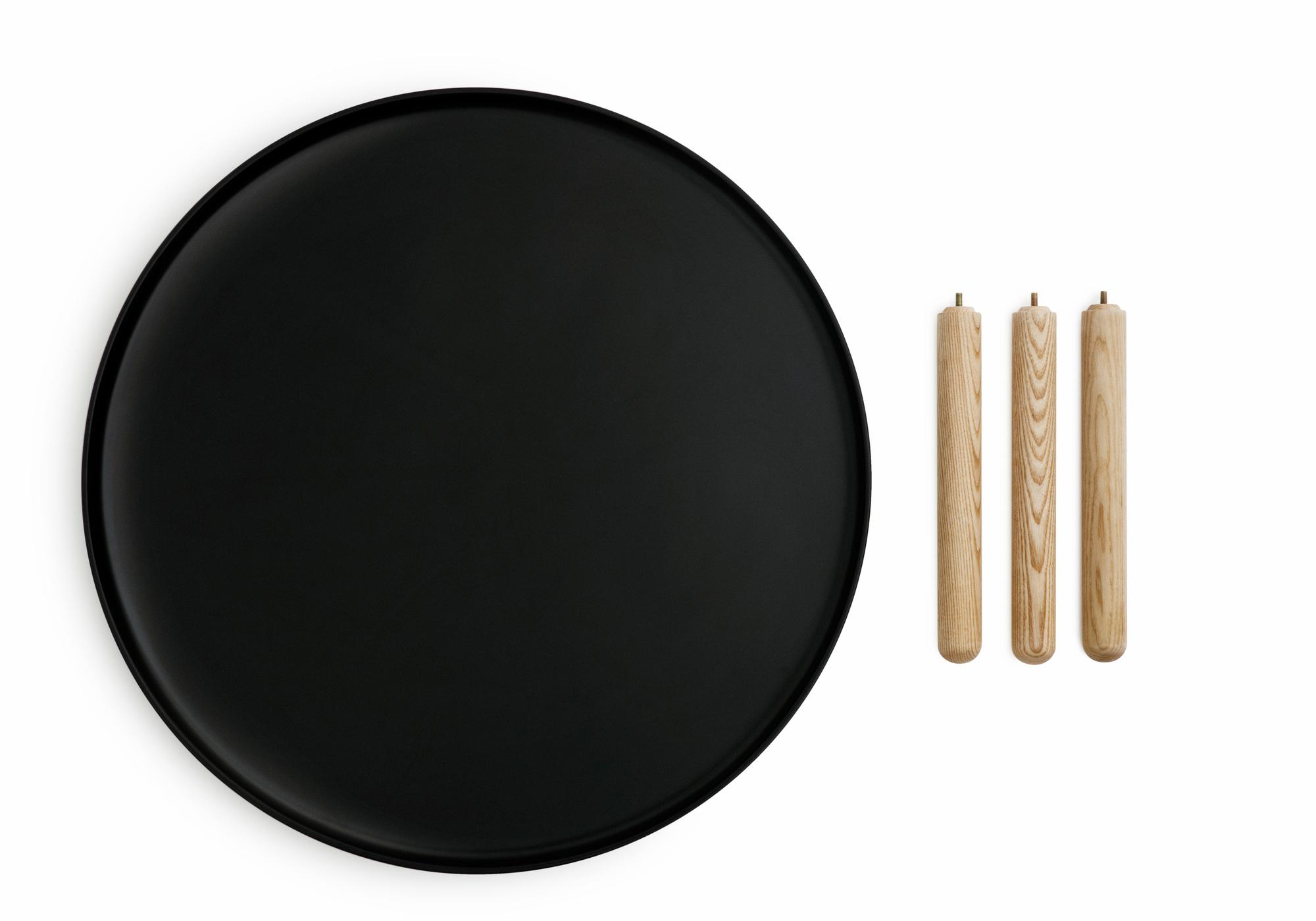 Schwarze Tischplatte und drei helle Holzbeine des Tablo Table Small Beistelltischs von Normann Copenhagen.