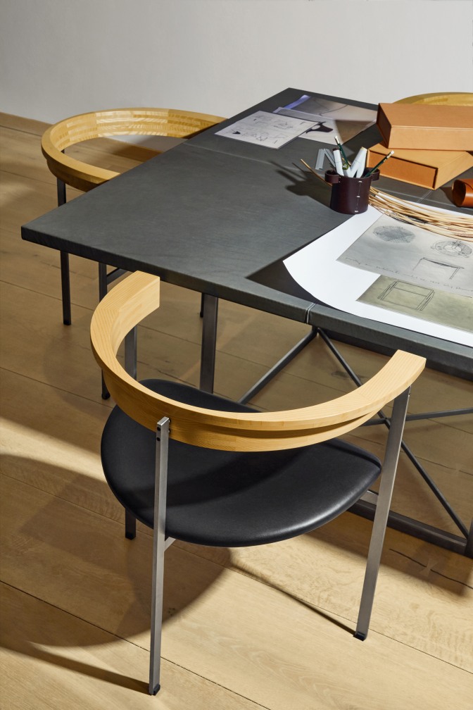 PK 40 Esstisch von Fritz Hansen mit Stuhl und Arbeitsmaterialien auf einer Holzoberfläche.