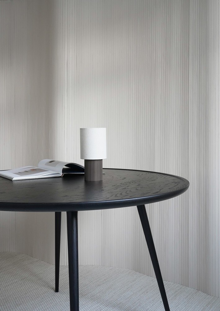 Runder Esstisch aus Eiche, schwarz gebeizt, mit Lampe und Buch. Accent Dining Table.