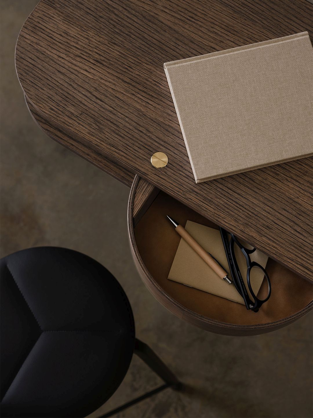 Detailaufnahme der Valet Wandkonsole aus geräucherter Eiche mit Stuhl, Notizbuch, Stift und Brille.