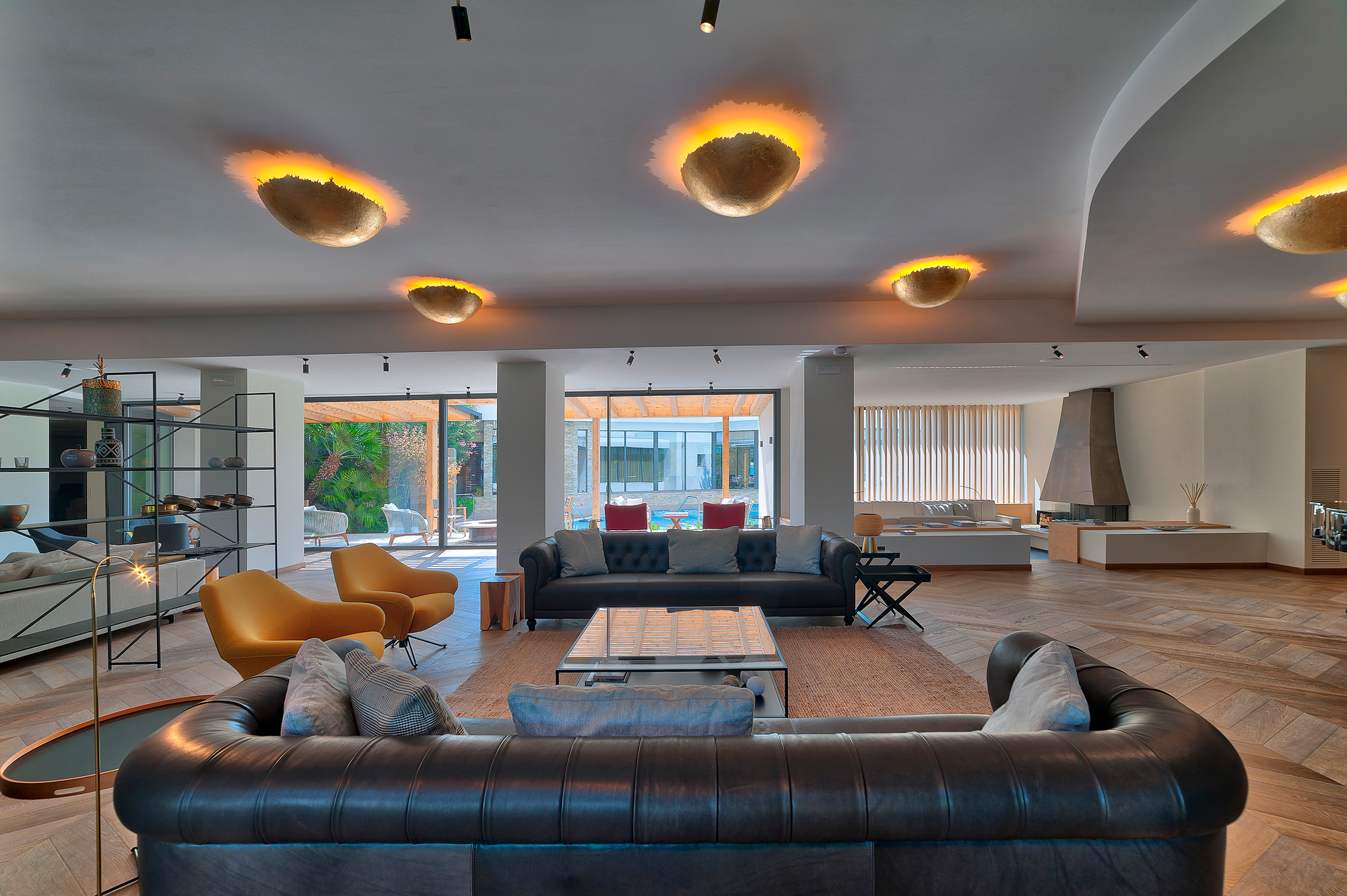 Innenaufnahme mit mehreren goldenen PostKrisi Deckenleuchten von Catellani & Smith im Wohnzimmer.