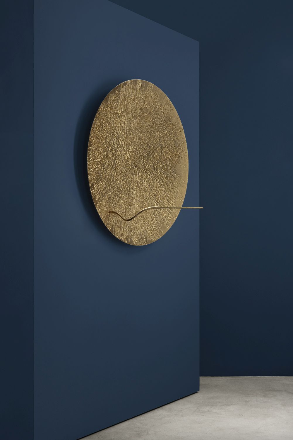 Goldene Bellatrix Wandleuchte von Catellani & Smith an blauer Wand. Design Lampe.