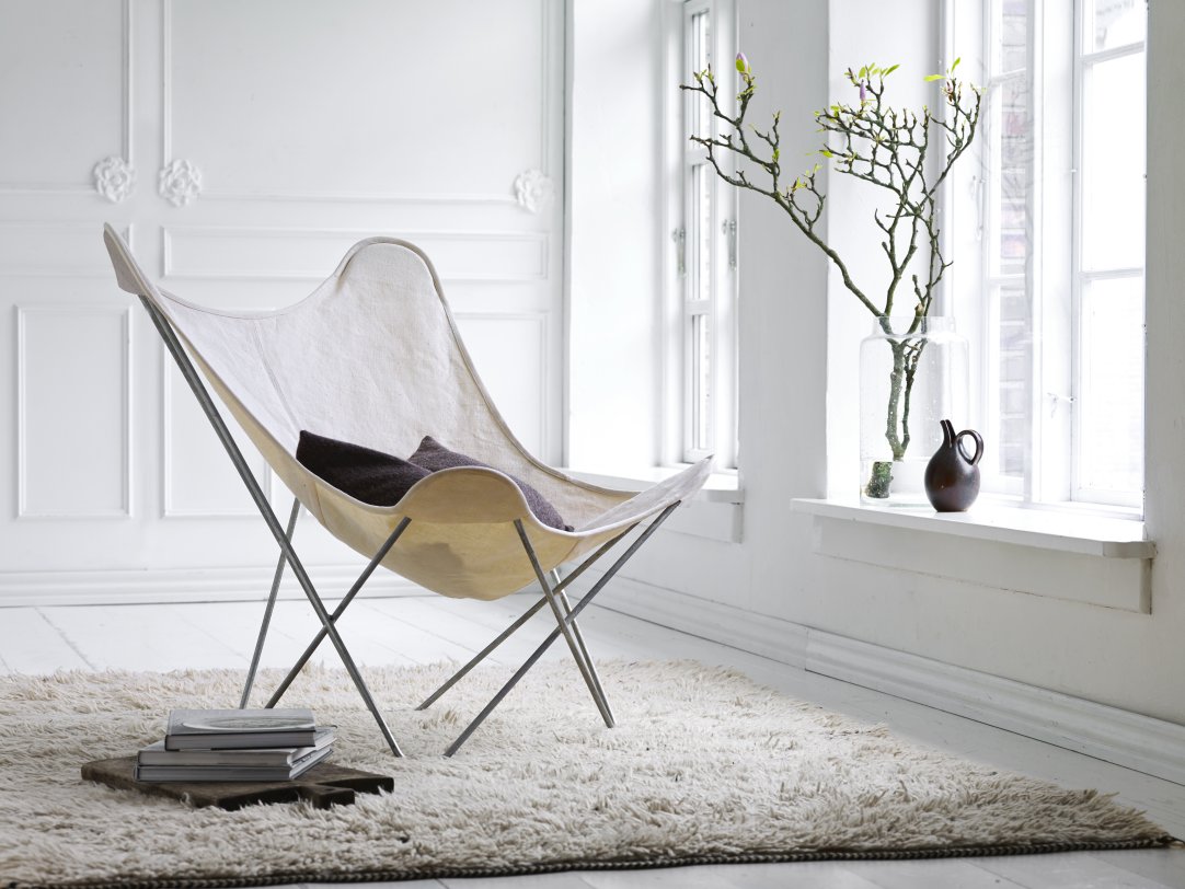 Canvas Mariposa Sessel mit hellem Bezug und Kissen, ein moderner Butterfly Chair für Wohnzimmer.
