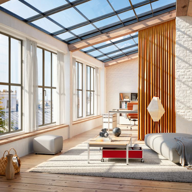 Heller Wohnraum mit USM Haller Tisch mit Rollbox in Rot unter einer Holzplatte.